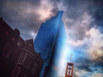 Low angle view of modern building against cloudy sky