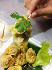 Close-up of person preparing food in plate