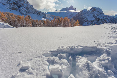 Close up of tracks in the snow, with mount civetta in the background, dolomites, italy