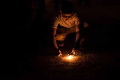 Full length of man with illuminated lights at night