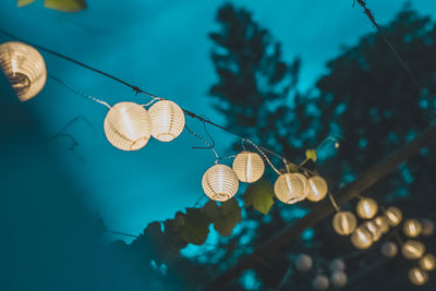 Low angle view of illuminated light bulbs at night