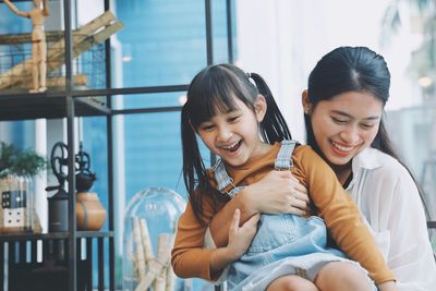 Happy mother and daughter sitting outdoors