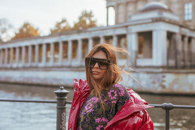 Portrait of woman standing against bridge