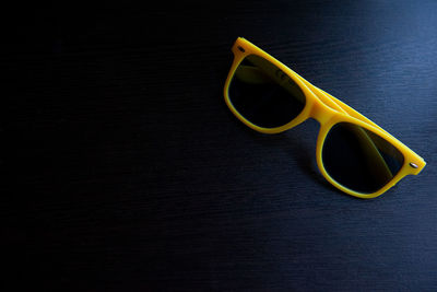 High angle view of yellow sunglasses on wooden table