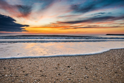 Scenic view of beach against sky during sunset