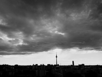 Buildings in city against cloudy sky