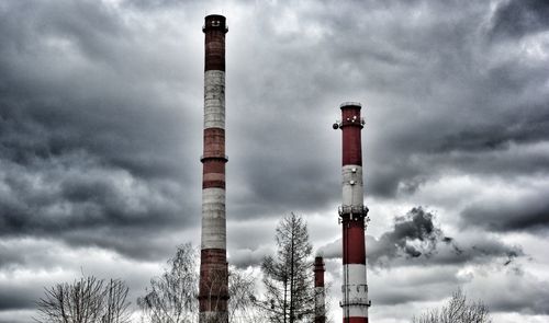 Low angle view of smoke stacks against sky