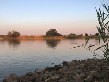 Scenic view of lake against sky at sunset