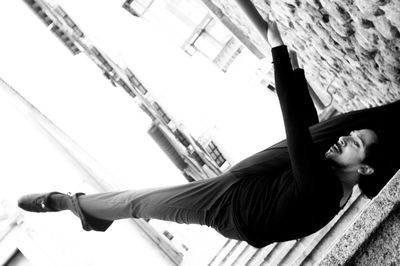 Low angle view of man hanging on railing over steps