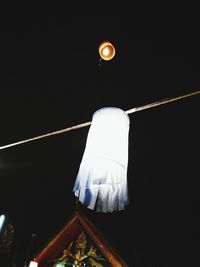Low angle view of illuminated lantern against clear sky at night