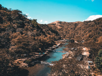 High angle view of river amidst trees against sky