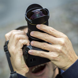 Low angle view of man photographing while standing outdoors