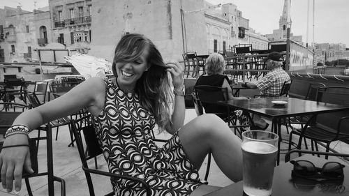 Woman with umbrella on balcony in city