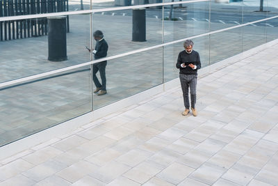 Mature handsome business man using a digital tablet outside office building