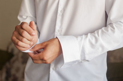 Midsection of man holding mobile phone