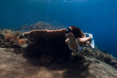 Rear view of woman swimming in sea