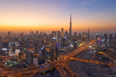 Aerial view of city lit up at sunset