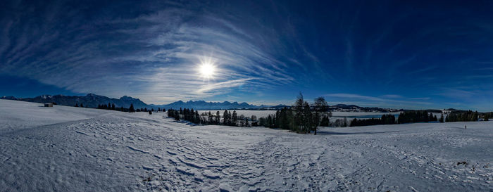 Scenic view of snow covered landscape against blue sky