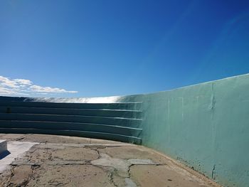 Low angle view of wall against blue sky