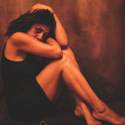 Midsection of woman sitting with arms raised