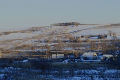 Snow covered landscape against clear sky