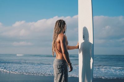 Man standing at beach against sky