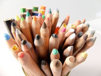 High angle view of colored pencils against white background