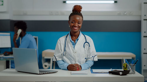 Portrait of smiling doctor standing at hospital