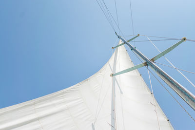 Low angle view of sailboat against clear blue sky