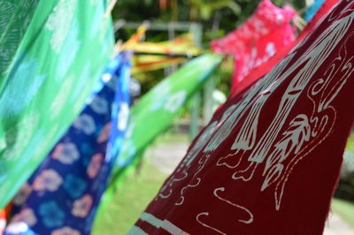 Close-up of multi colored flags hanging against blurred background