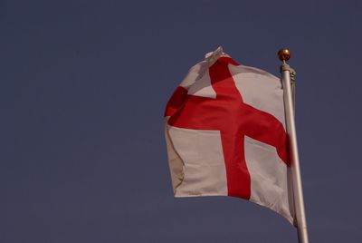 Low angle view of english flag against blue sky
