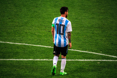 Rear view of man standing on soccer field