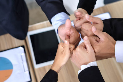 High angle view of colleagues gesturing thumbs up sign over desk