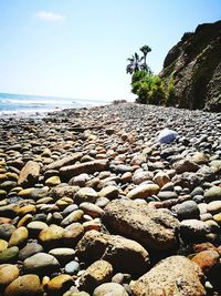 Surface level of sandy beach against clear sky