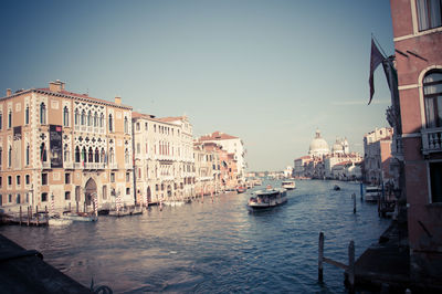 Boats in canal amidst buildings against sky