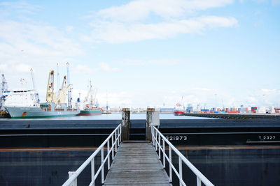 Boats moored at harbor against sky