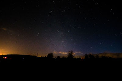 Silhouette landscape against star field at night