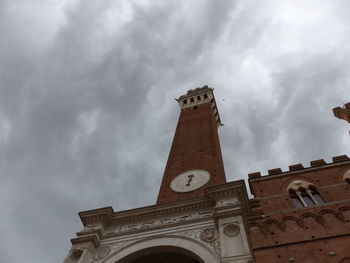 Low angle view of clock tower against cloudy sky