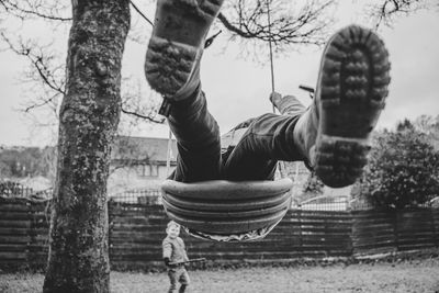 Low wide angle view of a girl on a swing in a rural neighborhood