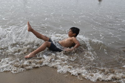 High angle view of shirtless man in sea