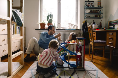 Father and daughters playing in bedroom at home