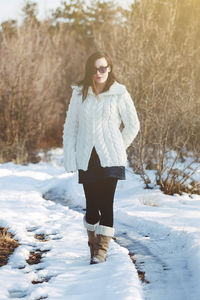 Young woman wearing sunglasses standing in snow