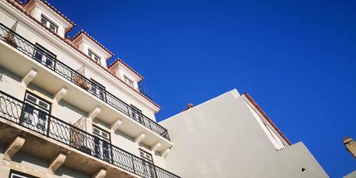 Low angle view of buildings against clear blue sky