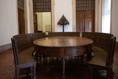 Empty chairs and table by window at home