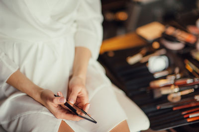 Midsection of woman holding paper