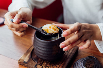 Close-up of woman having food in bowl on table