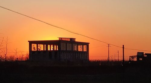 Silhouette buildings against sky during sunset