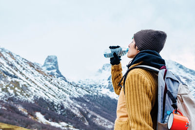 Man photographing on mountain during winter