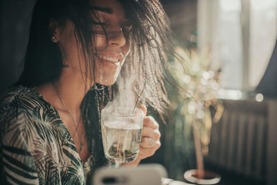 Portrait of a beautiful young woman drinking glass