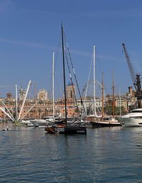 Sailboats in harbor against blue sky